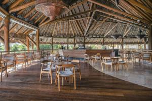 a restaurant with tables and chairs and a large ceiling at Iberostar Selection Praia do Forte in Praia do Forte