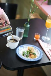 B&B Korsman Hanko في هانكو: طاولة مع طبق من الطعام وكوب من القهوة