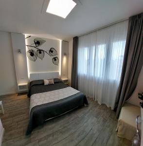 a bedroom with a bed and a large window at La Brise in Marina di Pietrasanta