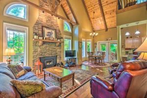 a living room filled with furniture and a stone fireplace at Serene Smoky Mountains Cabin Near Chatuge Lake in Hayesville