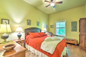 a bedroom with a bed with orange sheets and a fan at Serene Smoky Mountains Cabin Near Chatuge Lake in Hayesville