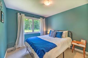 a blue bedroom with a bed and a window at Cozy Whitehall Hideaway with Hot Tub and Chiminea! in Whitehall