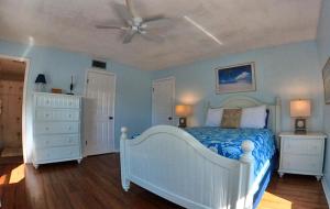 1 dormitorio con cama blanca y ventilador de techo en Sea Club Condo #1, en Clearwater Beach