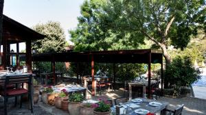 a patio with tables and chairs and a pavilion at Fener Motel in Şile