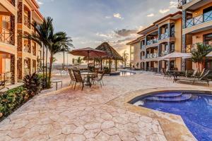 Un complejo con piscina, mesas y sillas. en Bahía Encantada G1, en Jacó