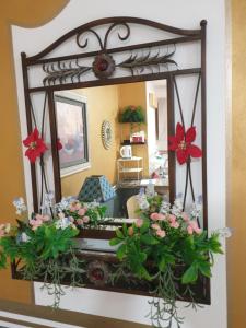 espejo en la pared con flores en la sala de estar en Precioso Estudio en Arroyo de la Miel . Centro, en Benalmádena