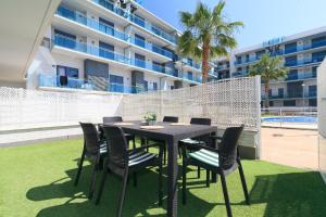 - une table à manger et des chaises sur une terrasse à côté d'un bâtiment dans l'établissement UHC Mar Augusta Family Complex, à Cambrils 39 autres photos