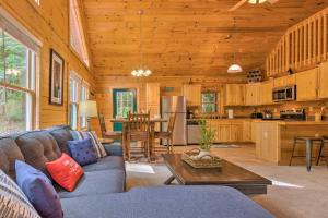 un soggiorno con divano e tavolo di Moonshine Manor Cabin with Fire Pit and Hot Tub! a Lake Lure