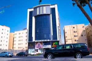 a black truck parked in front of a building at فندق منتصف البيعة in Ash Shuhadāʼ ash Shamālīyah