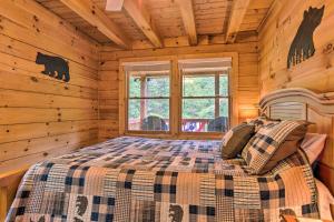 una camera con un letto in una baita di tronchi di Moonshine Manor Cabin with Fire Pit and Hot Tub! a Lake Lure