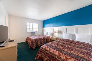 a hotel room with two beds and a flat screen tv at Captain's Table Hotel by Everglades Adventures in Everglades City