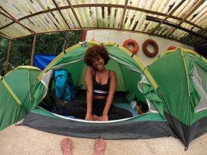 a woman sitting inside of a tent at Ready Camp e Suítes da Cachoeira in Abraão