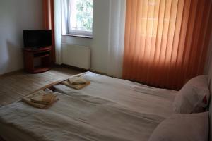 1 cama no hecha en una habitación con ventana en Willa Maxim, en Lądek-Zdrój