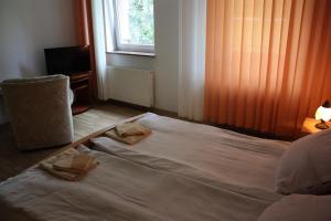 Una cama en un dormitorio con dos toallas. en Willa Maxim, en Lądek-Zdrój