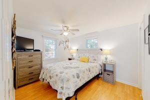 a white bedroom with a bed and a tv at Harborview Villa in Harwich Port