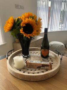 a table with a bottle of wine and a vase of flowers at Charming Apartment in Ashley Cross in Parkstone