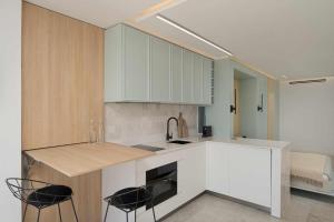 Una cocina con gabinetes blancos y sillas negras. en SG Canteras View Deluxe, en Las Palmas de Gran Canaria 8 fotos más
