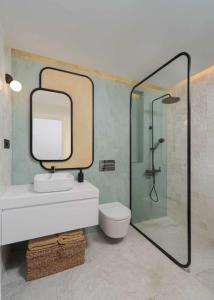 Un baño con lavabo y ducha con espejo. en SG Canteras View Deluxe, en Las Palmas de Gran Canaria