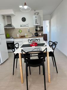 eine Küche mit einem Tisch und Stühlen im Zimmer in der Unterkunft APART trelew 3 in Trelew