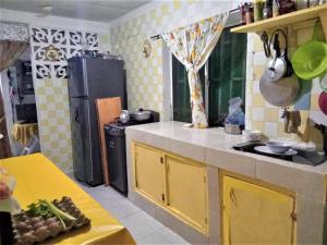 eine Küche mit gelben Schränken und einem schwarzen Kühlschrank in der Unterkunft Posada Nativa Green Sea San Luis in Buenavista + 22 Fotos