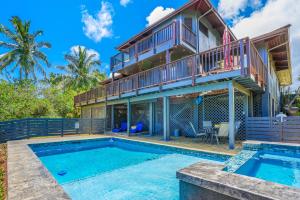 uma villa com uma piscina e uma casa em Saltwater Hale em Princeville