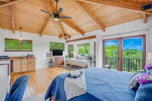 uma sala de estar com uma cama azul e um tecto de madeira em Saltwater Hale em Princeville