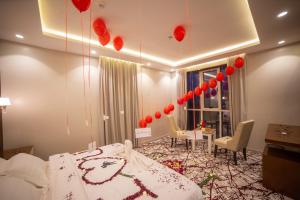 a room with a bed and a table with red balloons at فندق منتصف البيعة in Ash Shuhadāʼ ash Shamālīyah