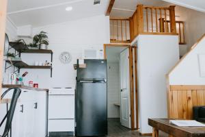 a kitchen with a refrigerator and a staircase at The Perch- Texas Tiny Haus with amazing views in Spring Branch