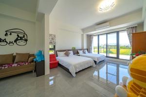 a bedroom with two beds and a couch and a window at 橙香民宿 in Dongshan