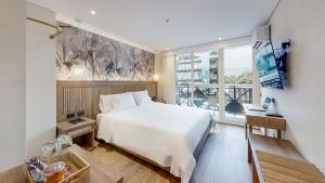 une chambre avec un lit blanc et une grande fenêtre dans l'établissement Origen Hotel Boutique, à Medellín 65 autres photos