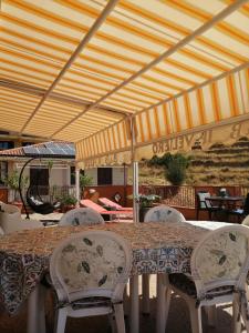 stół i krzesła pod namiotem na patio w obiekcie Il Veliero w mieście Roccalumera