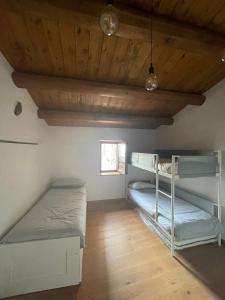 CalascioにあるLa casa di mezzoの木製天井のドミトリールームの二段ベッド2台分です。