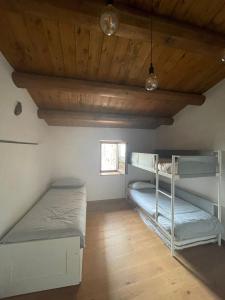two bunk beds in a room with a wooden ceiling at La casa di mezzo in Calascio