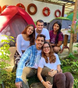 un groupe de personnes posant une photo devant une tente dans l'établissement Ready Camp e Suítes da Cachoeira, à Abraão