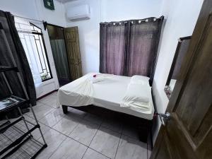 um quarto com uma cama num quarto com uma janela em Natural Experience House em Tortuguero