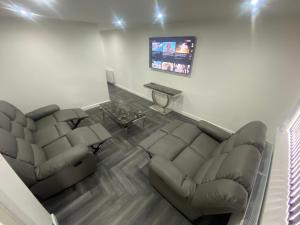 a living room with a couch and a tv at Entire Luxury Holiday Home leeds in Beeston
