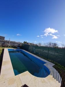 a swimming pool with blue water and a fence at Cabañas De Cero in Mercedes