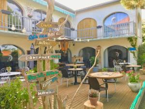 een restaurant met tafels en stoelen en een bord met pijlen bij L'Ecume des Jours in Soulac-sur-Mer