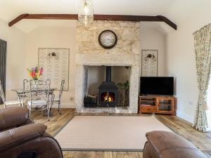 a living room with a fireplace and a tv at The Forge in Falmouth