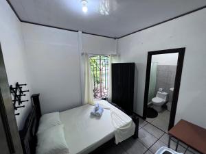 a bedroom with a bed and a bathroom with a window at Natural Experience House in Tortuguero