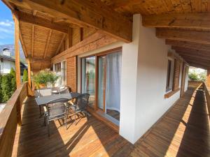 a wooden deck with a table and chairs on it at Living8-Appartements in Bad Ischl