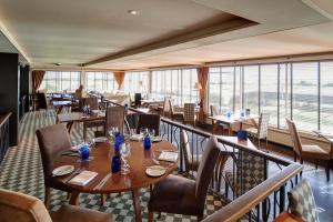 un restaurante con mesas, sillas y ventanas grandes en Royal Golf Hotel en Dornoch