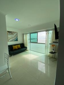 a living room with a couch and a large window at Ecusuites Riverfront One Vista al Río Jacuzzi Hidro in Guayaquil