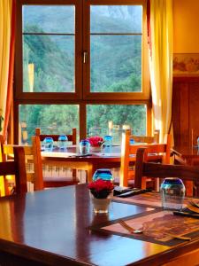 een eetkamer met een tafel en een groot raam bij Hotel Cumbres de Valdeón in Posada de Valdeón