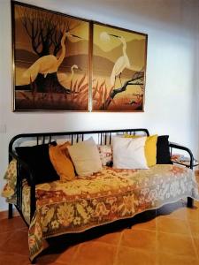 Bett in einem Zimmer mit Bildern an der Wand in der Unterkunft Vila Saraz in Campinho