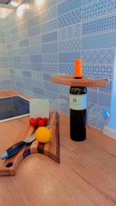 a bottle of wine and a cutting board with a knife at Casa Alice in Ližnjan
