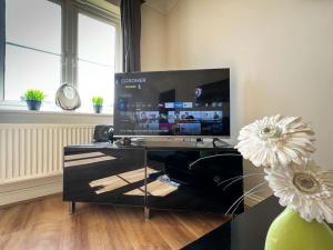 a living room with a large flat screen tv at 4 Bedroom house for Contractors,family,free parking,study,internet in ipswich in Ipswich
