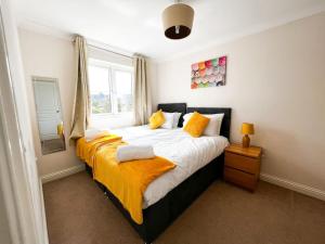 a bedroom with a large bed with yellow sheets at 4 Bedroom house for Contractors,family,free parking,study,internet in ipswich in Ipswich