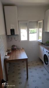 uma cozinha com uma mesa e uma máquina de lavar roupa em Un hogar en el Pinar em Navaleno