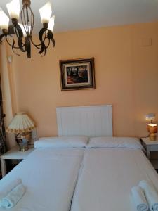 レタマルにあるCasa Cabo de Gataのシャンデリア付きのベッドルームに白いベッド2台